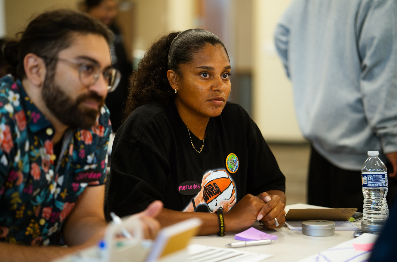 A Family Council member sharing community-driven priorities on a flip chart